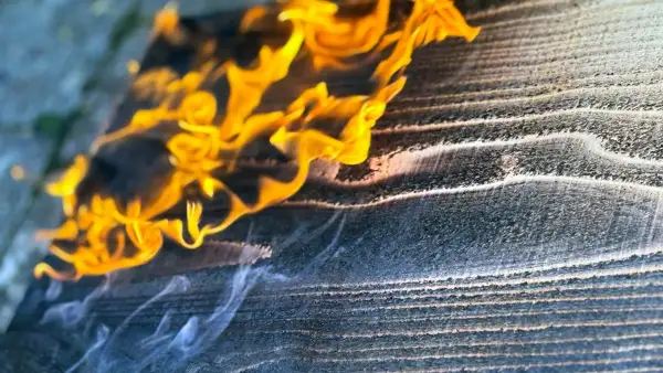 Propane flame beginning to scorch the cedar board in the Yakisugi process.