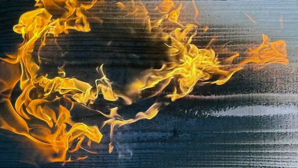 Flowing flame pattern moving across cedar grain mid-burn.