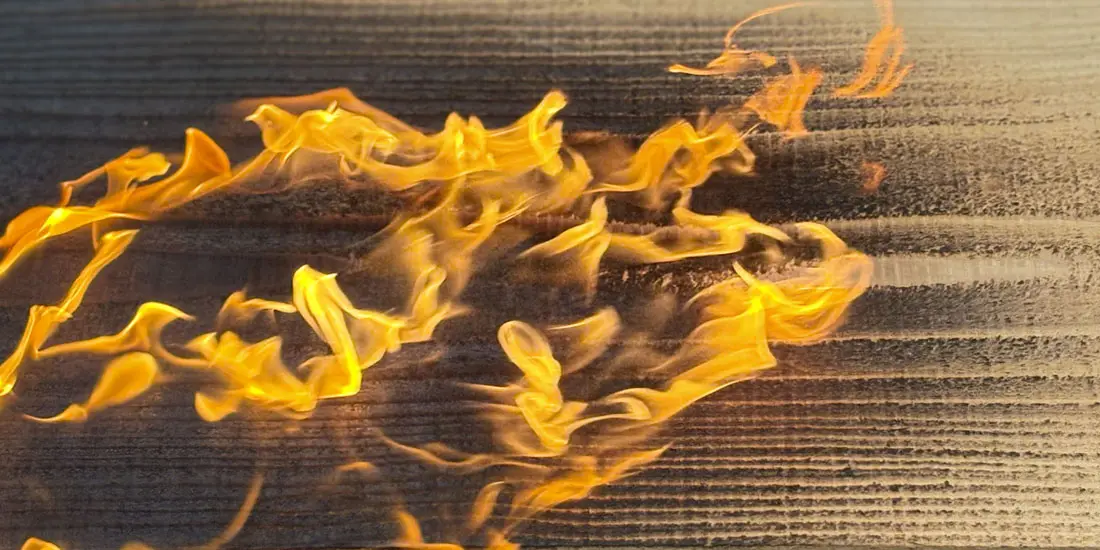 Close-up of Yakisugi flames charring Western Red Cedar to create a durable, textured finish