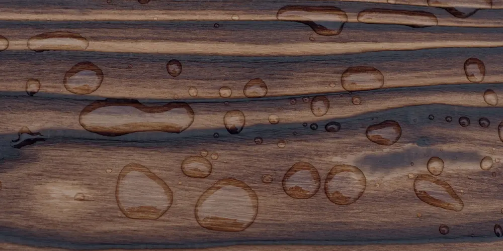 Yakisugi timber with water droplets beading on a protective oiled surface showing outdoor water resistance